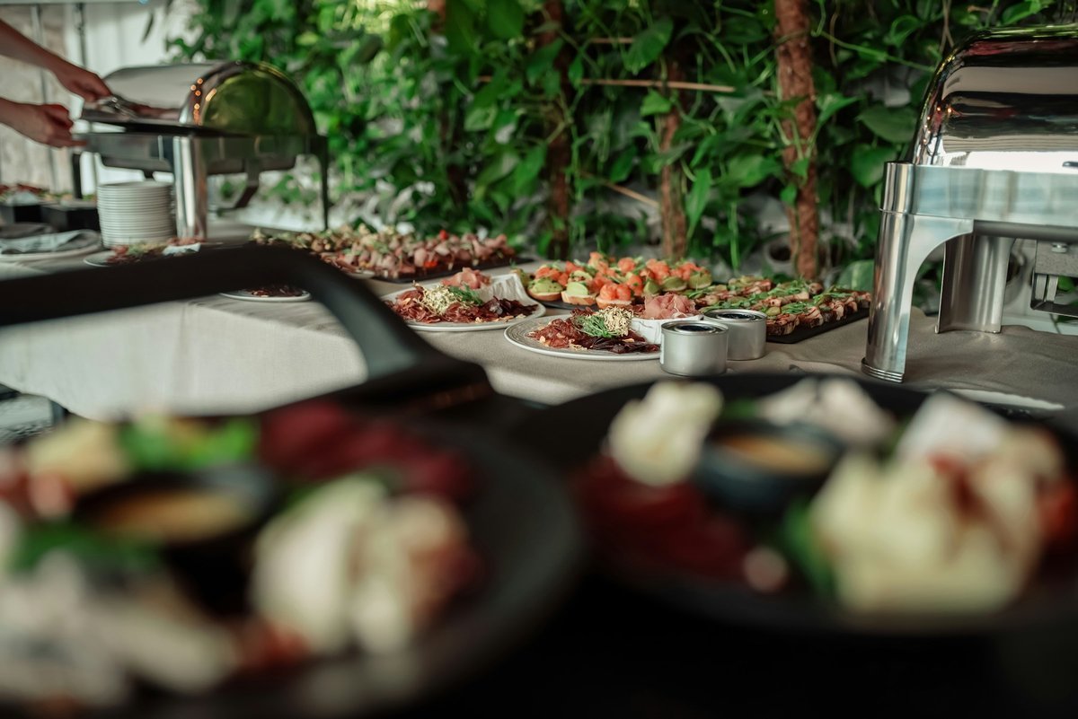 A bright, fresh catering spread with appetizers and a chafing dish